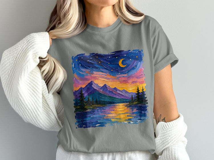 T-shirt features a colorful, textured painting of a mountain lake scene at night with a moon and stars.