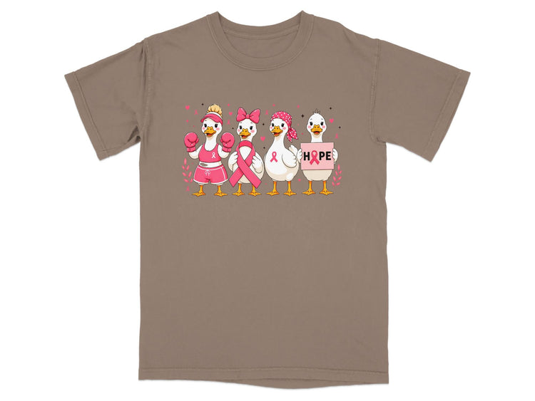 Four cartoon ducks with pink ribbons and the word "HOPE" on a brown t-shirt.