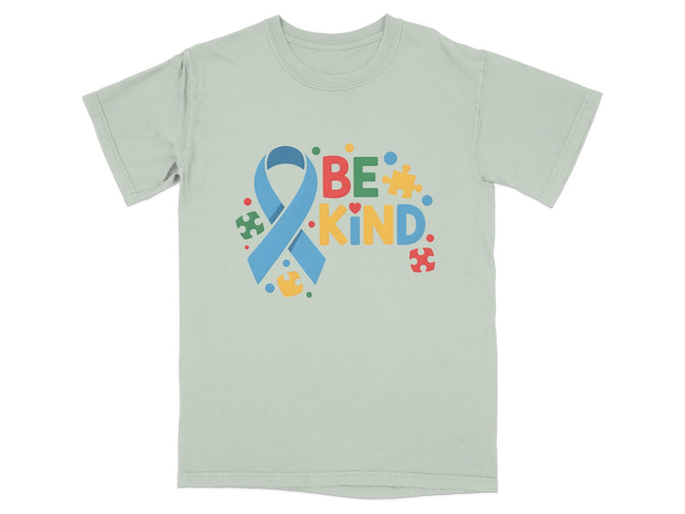 Light green t-shirt with blue ribbon and "BE KIND" text surrounded by puzzle pieces.