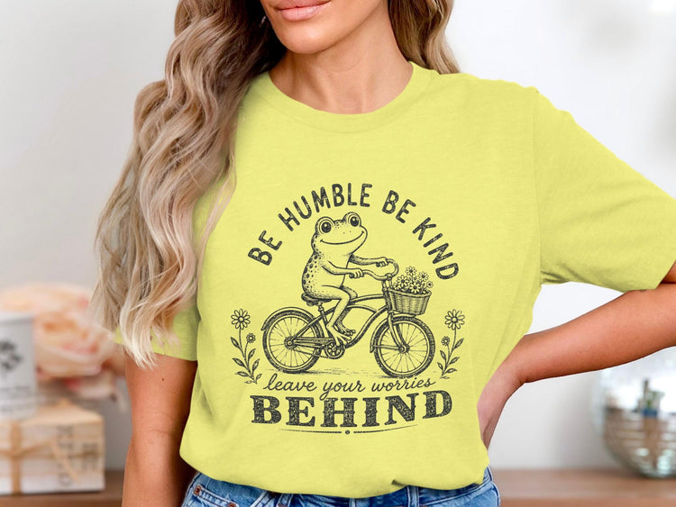 Frog riding bicycle with flowers, text "BE HUMBLE BE KIND leave your worries BEHIND".