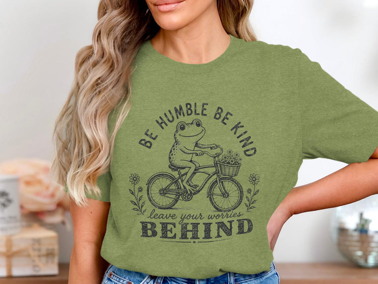 Frog riding bicycle with flowers, "Be Humble Be Kind leave your worries BEHIND".