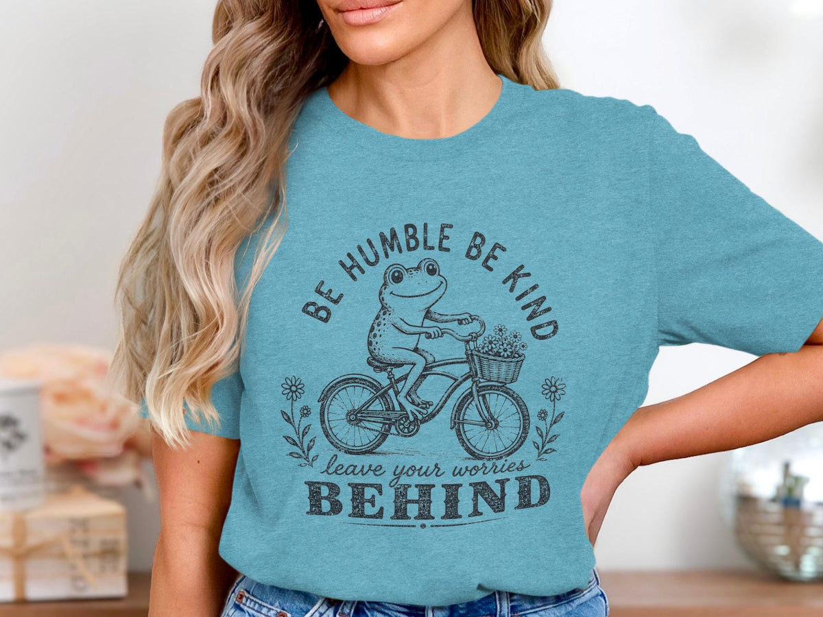 Frog riding bicycle with flowers, "Be Humble Be Kind, Leave Your Worries Behind."