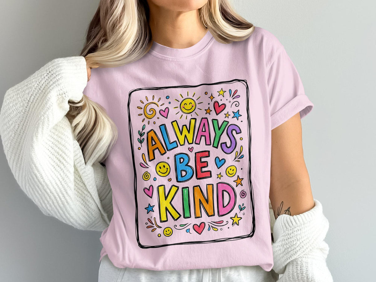 Pink t-shirt with colorful "Always Be Kind" text and playful suns and hearts.
