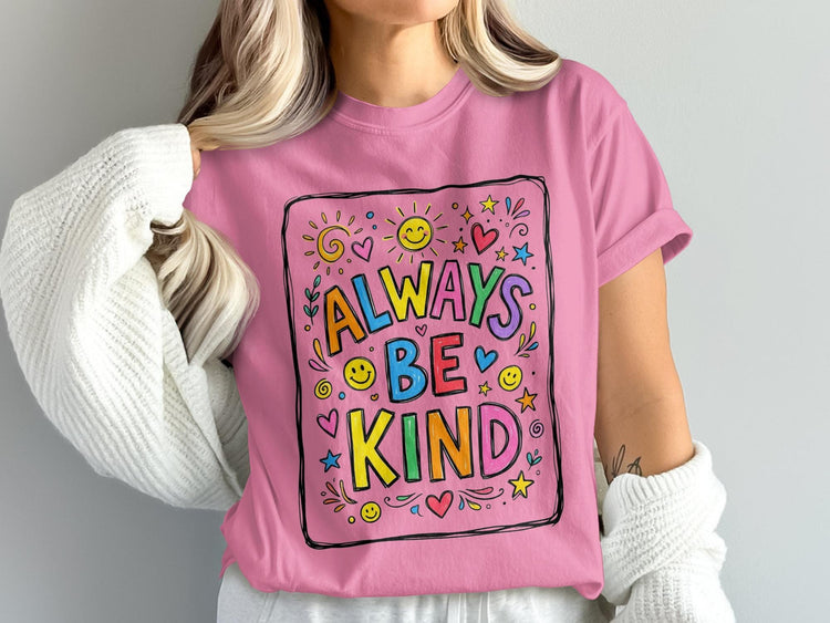 Pink t-shirt with "Always Be Kind" text and colorful doodle art.