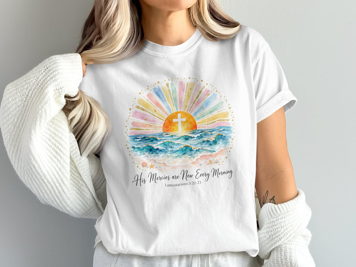 White t-shirt with watercolor sunrise, cross, ocean waves, and text.