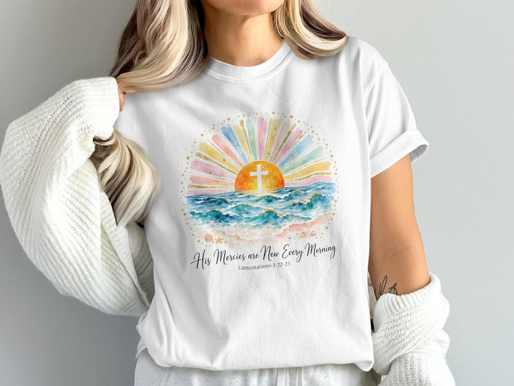 White t-shirt with watercolor sunrise, cross, ocean waves, and text.