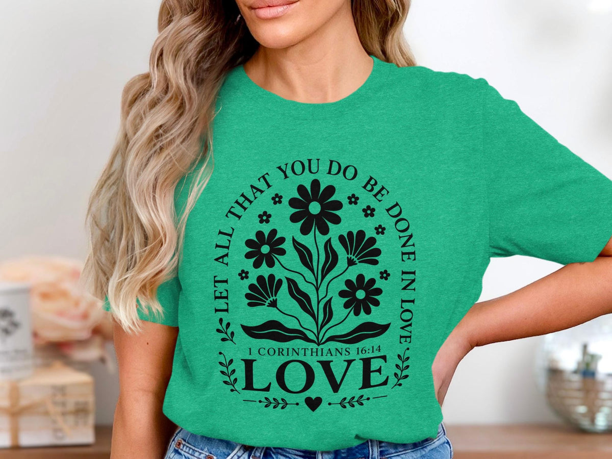 Green t-shirt with black floral design and text "LET ALL THAT YOU DO BE DONE IN LOVE 1 CORINTHIANS 16:14 LOVE".