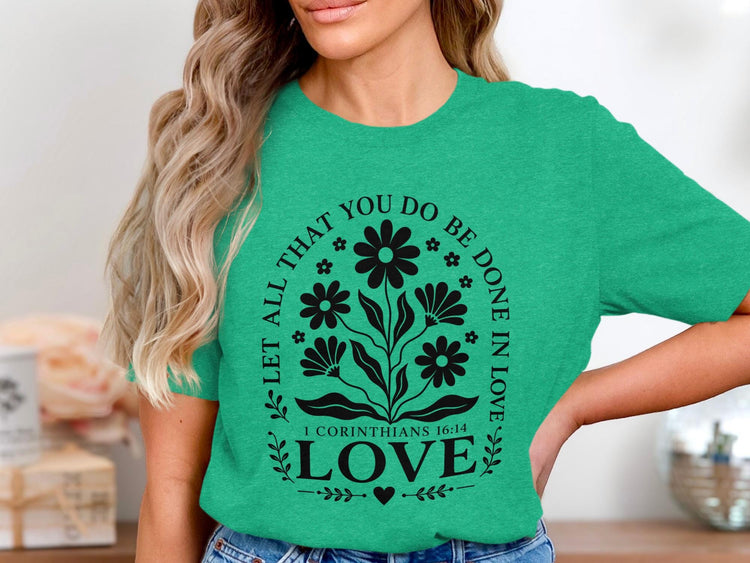 Green t-shirt with black floral design and text "LET ALL THAT YOU DO BE DONE IN LOVE 1 CORINTHIANS 16:14 LOVE".