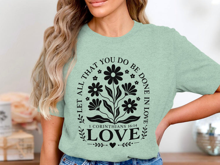 Green t-shirt with floral design and text "LET ALL THAT YOU DO BE DONE IN LOVE".