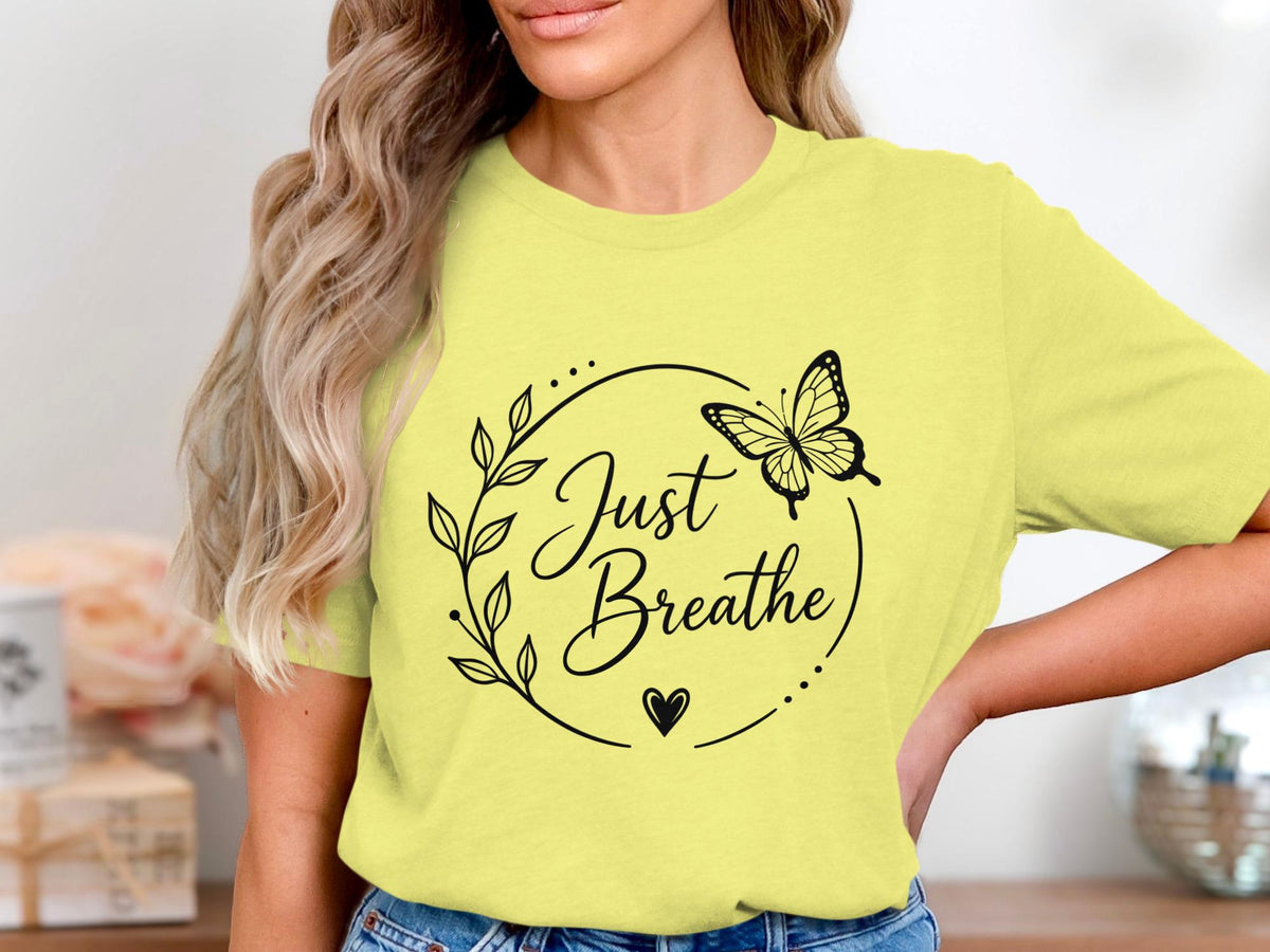 Yellow t-shirt with black floral design and "Just Breathe" text.