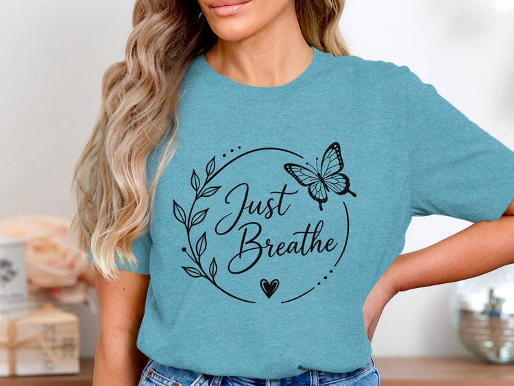 Teal t-shirt with black "Just Breathe" text, butterfly, leaves, and heart graphic.