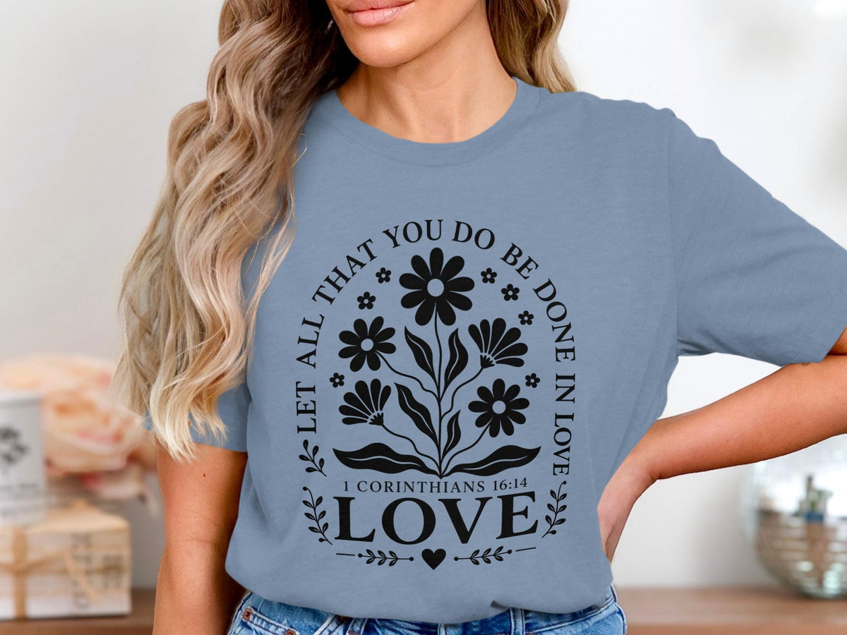Blue t-shirt with black floral design and text "Let all that you do be done in love"