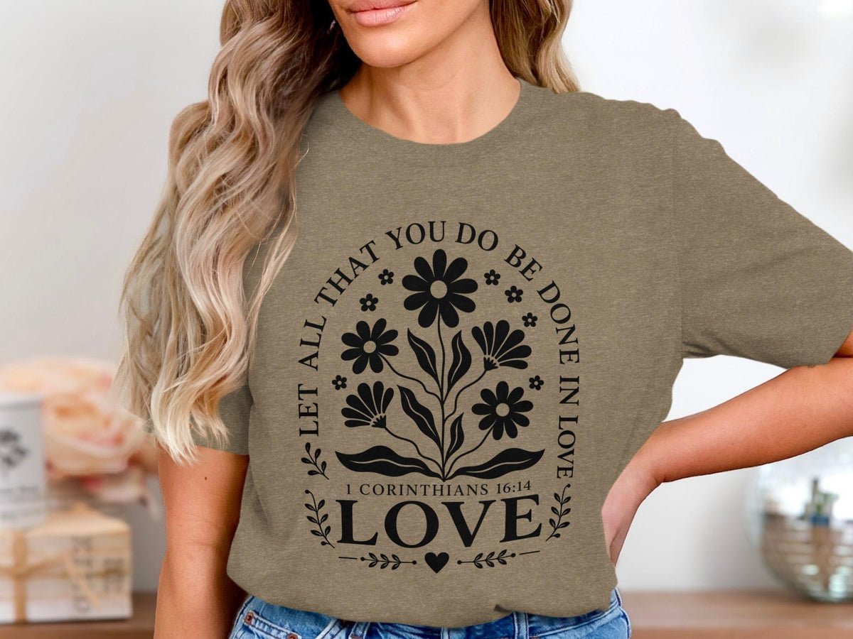T-shirt with "Let All That You Do Be Done In Love 1 Corinthians 16:14" text and floral design.
