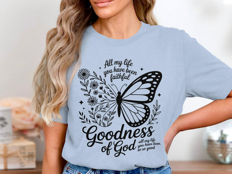 Light blue t-shirt with butterfly, flowers, and "Goodness of God" text.