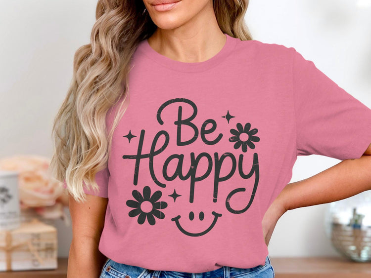 Pink t-shirt with "Be Happy" text, flowers, and smiley face graphic.