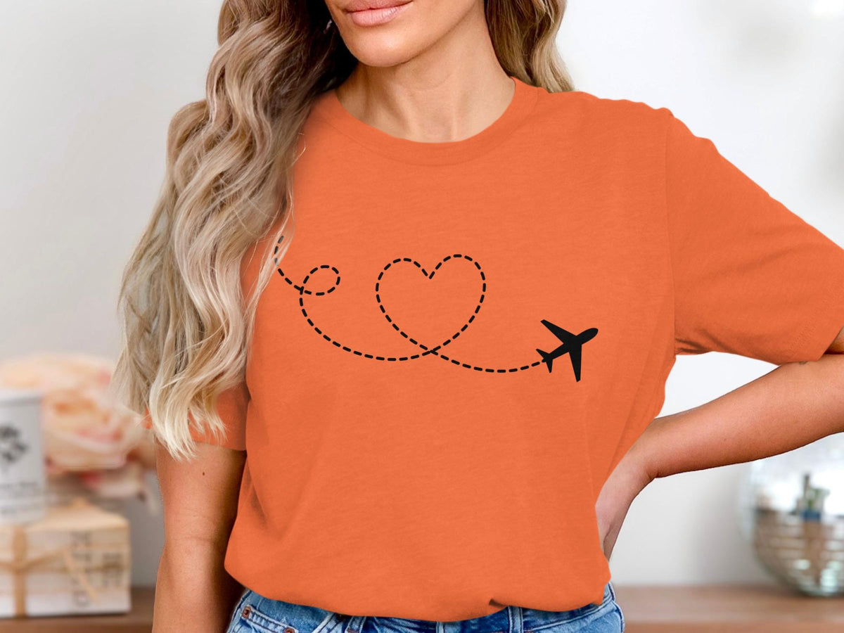 Orange t-shirt with a black airplane and dashed heart traced path.