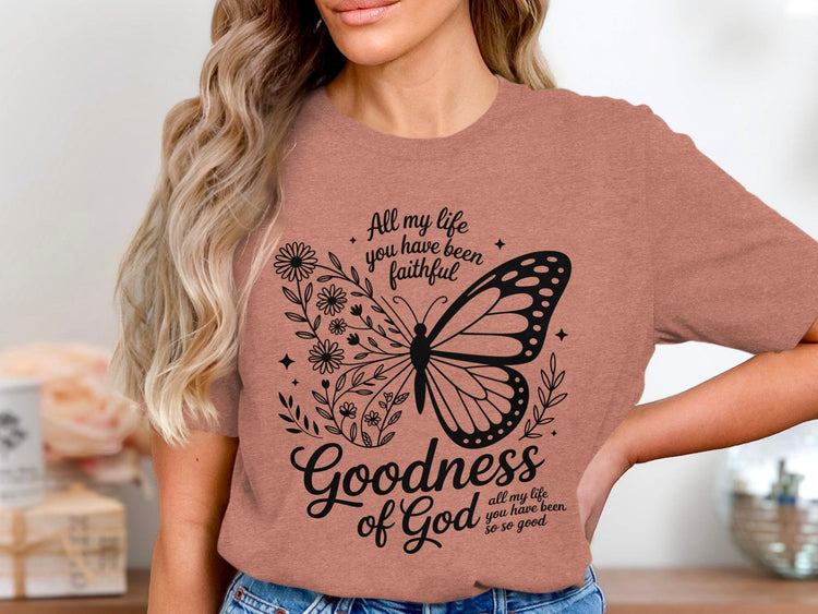 Salmon t-shirt with black butterfly and floral design. Text reads "Goodness of God".
