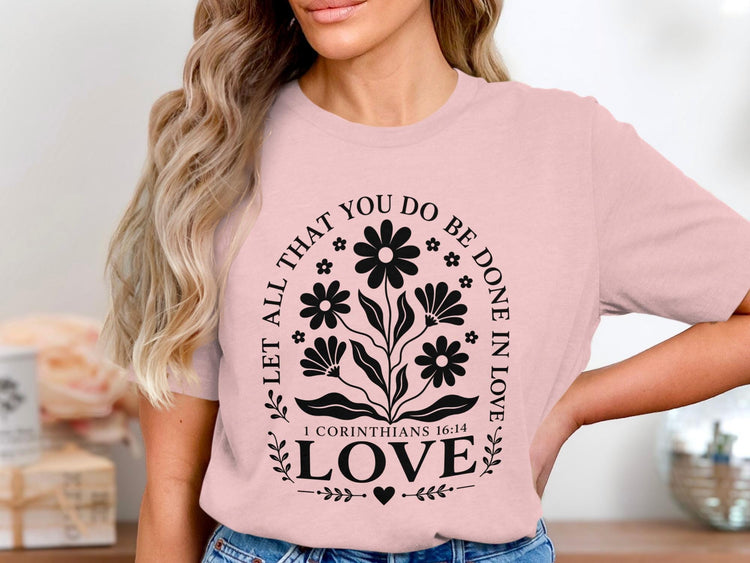 Pink t-shirt with black floral design and "Let All That You Do Be Done In Love" text.