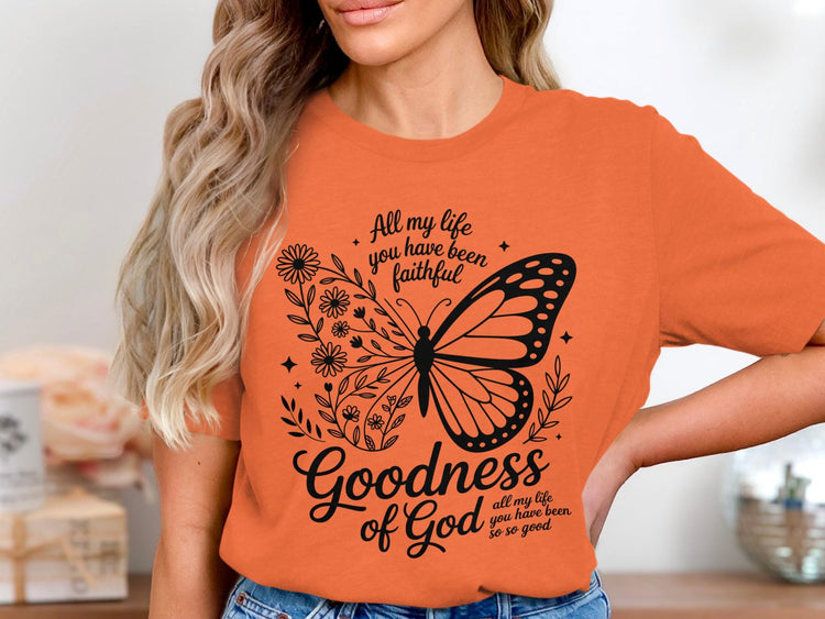 Orange t-shirt with butterfly, floral, and text "Goodness of God".