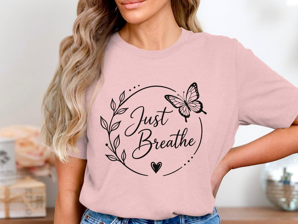 Pink t-shirt with black graphic of butterfly and text "Just Breathe".