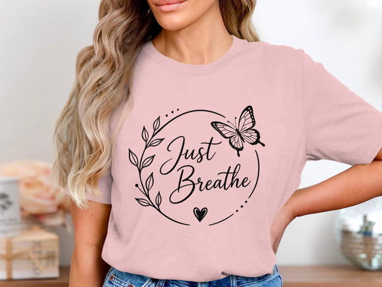 Pink t-shirt with black graphic of butterfly and text "Just Breathe".