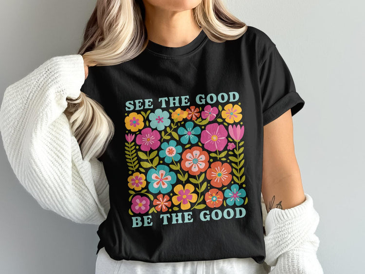 Black t-shirt with colorful flowers and the text "SEE THE GOOD BE THE GOOD".