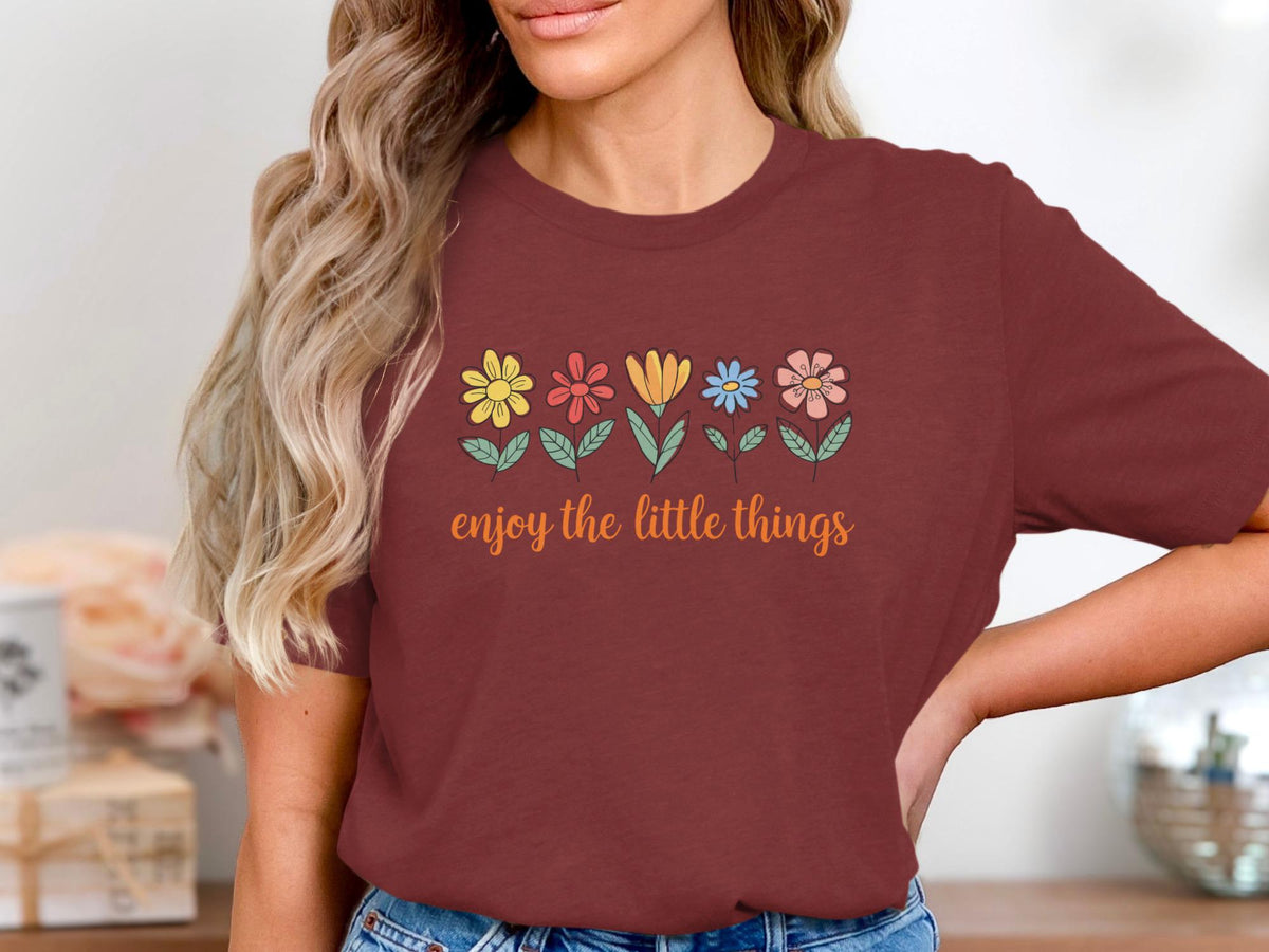 Maroon t-shirt with a line of colorful flowers and "enjoy the little things" text.