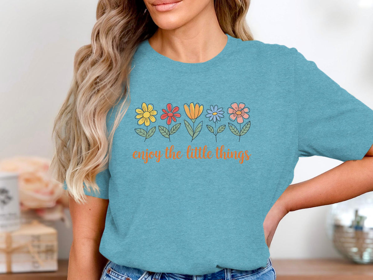Teal t-shirt with colorful flowers and "enjoy the little things" text.