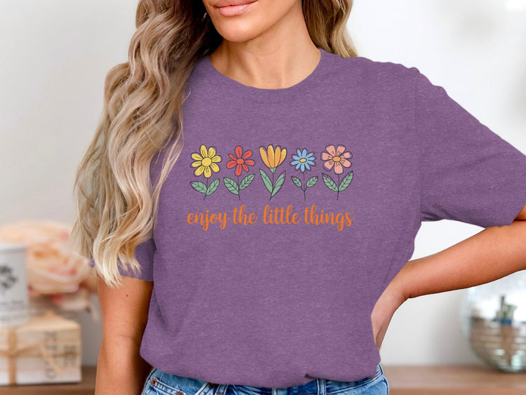 Purple t-shirt with a line of colorful flowers and the text "enjoy the little things".