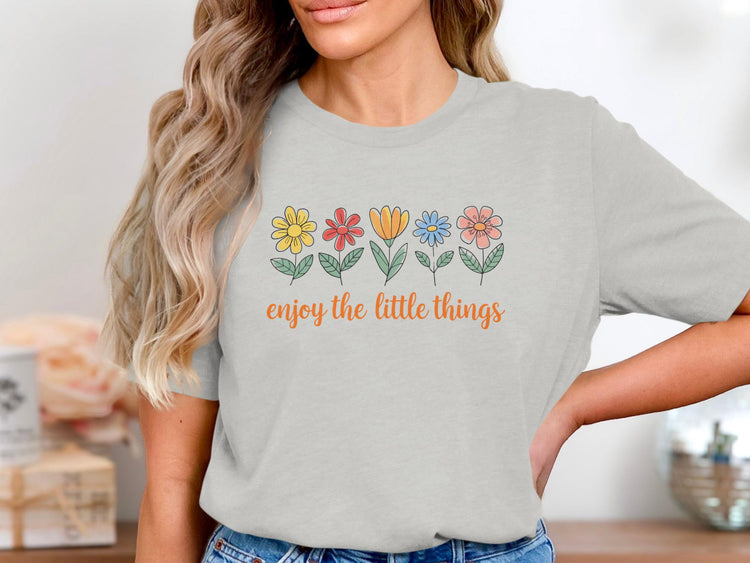 Light grey t-shirt with colorful flowers and orange text "enjoy the little things".