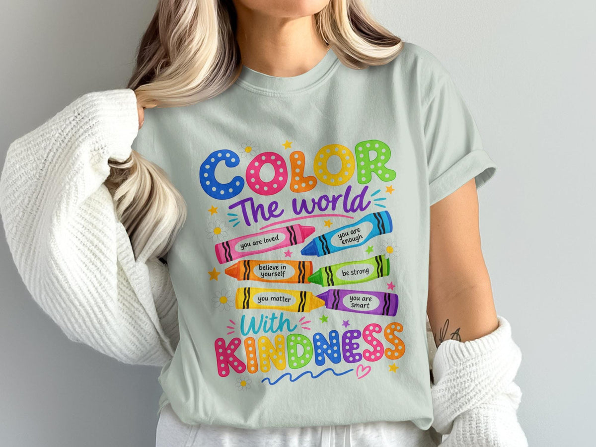Light green t-shirt with "Color The World With Kindness" text and drawings of crayons and flowers.