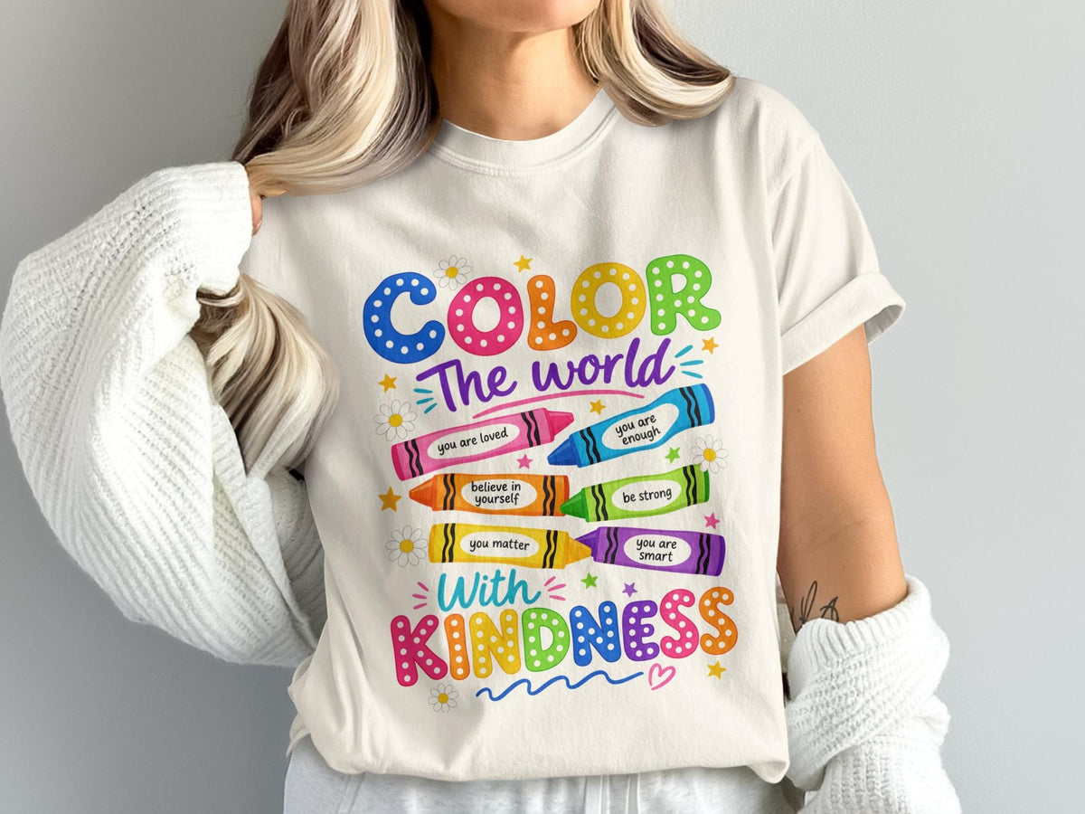 "Color The World With Kindness" text and inspirational crayon designs on a t-shirt.