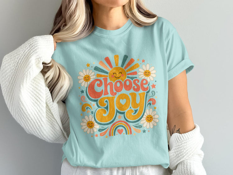 Light blue t-shirt with "Choose Joy" text, sun, daisies, and rainbow graphic.