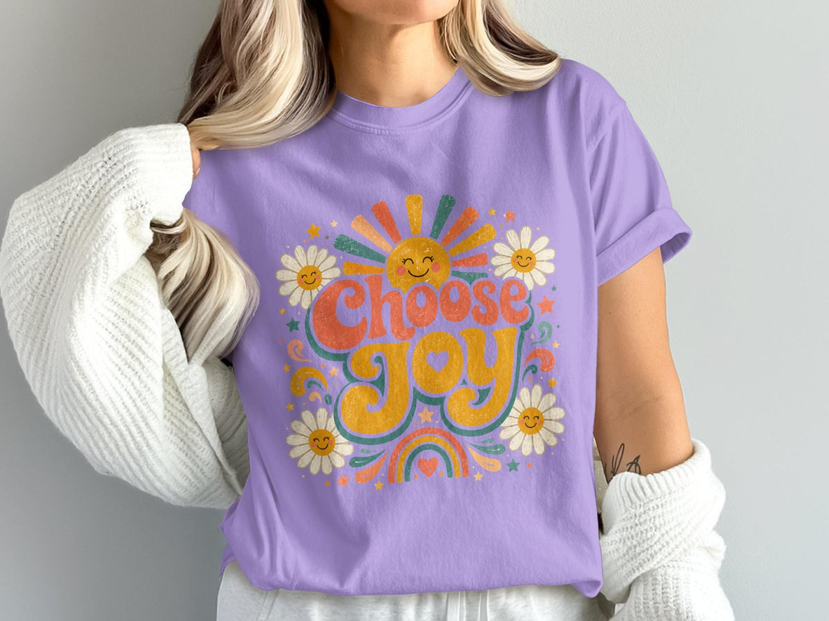 Purple t-shirt with "Choose Joy" text, a happy sun, daisies, and rainbow graphics.