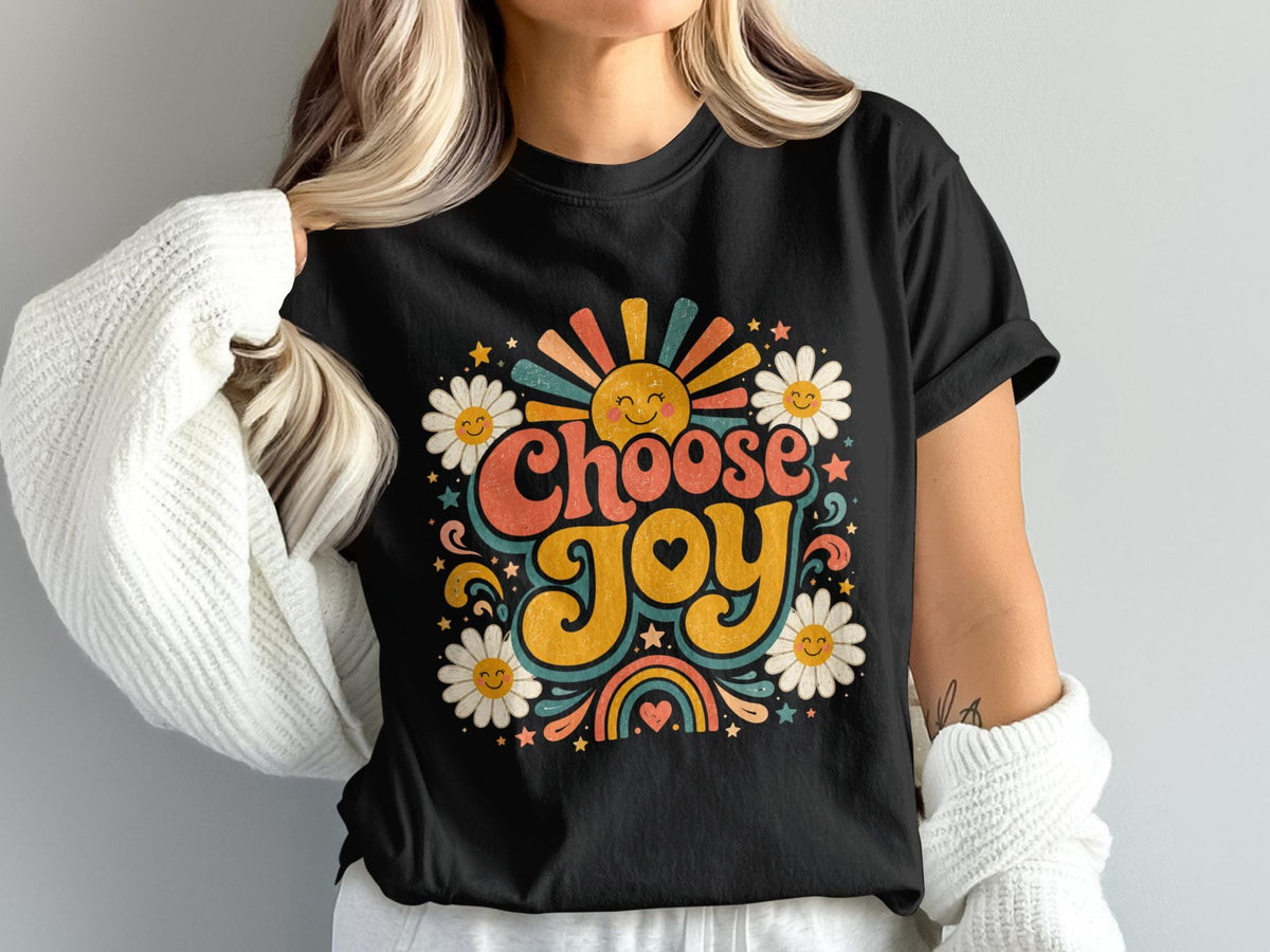 Black t-shirt with "Choose Joy" text, smiling sun, daisies, and rainbow design.