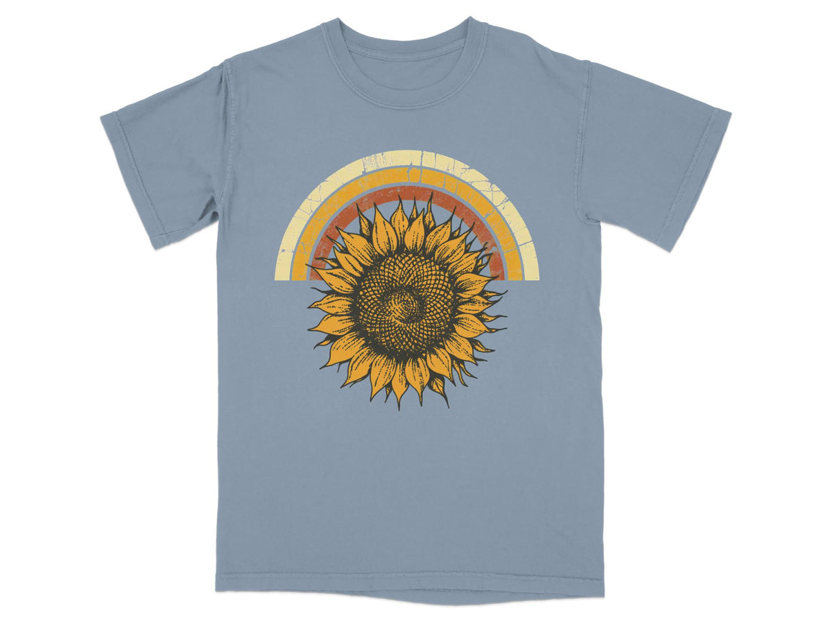 Blue t-shirt with a vintage-style distressed rainbow and sunflower graphic.