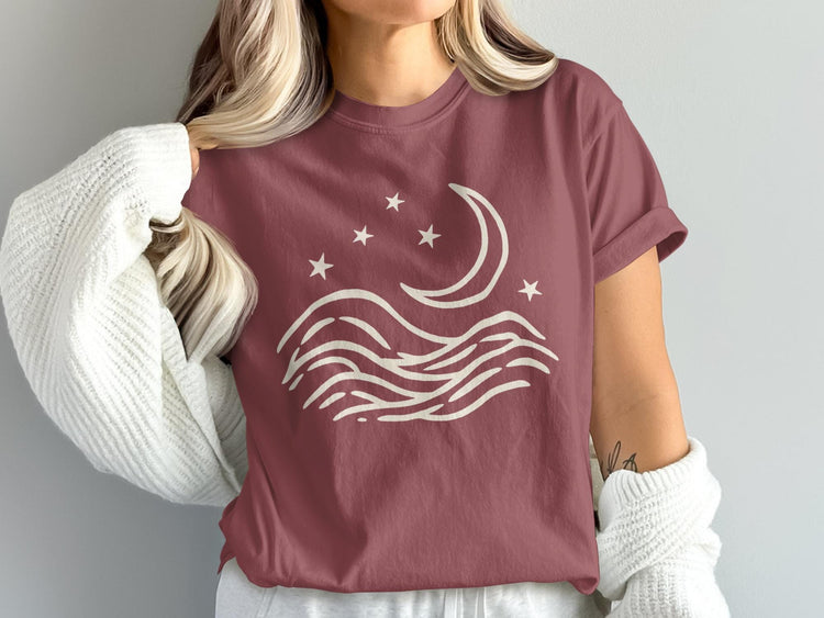 T-shirt with cream moon, stars, and wave graphic.