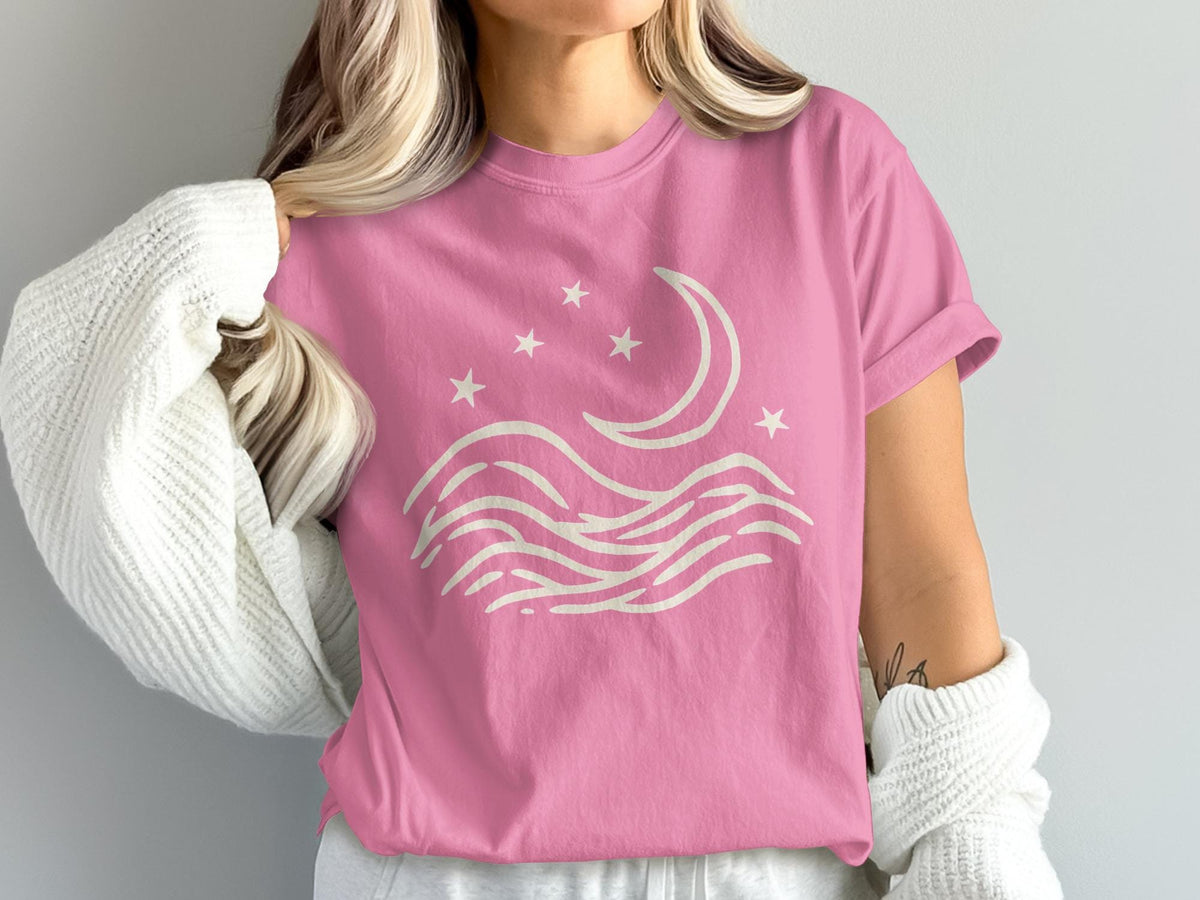 Pink t-shirt with cream crescent moon, stars, and wave design.