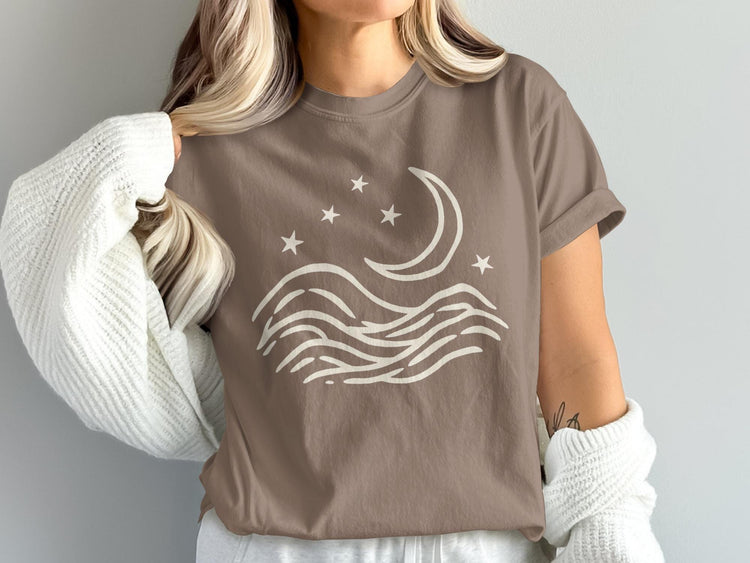 Brown t-shirt with white graphic of moon, stars, and wavy lines.