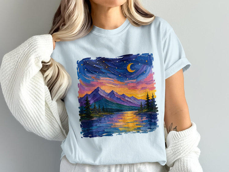 Light blue t-shirt with a colorful, textured mountain landscape and crescent moon at sunset.