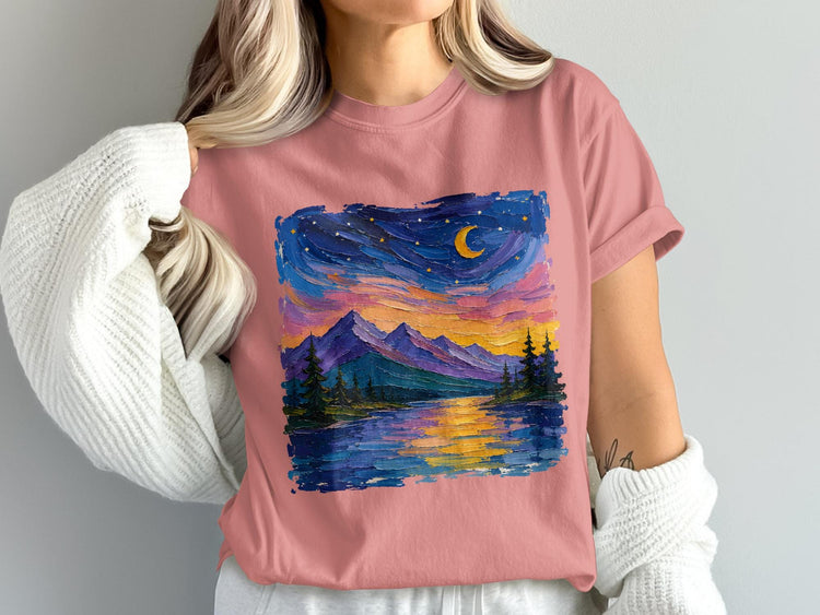 Pink t-shirt featuring a colorful, textured landscape painting of mountains, lake, and starry sky.
