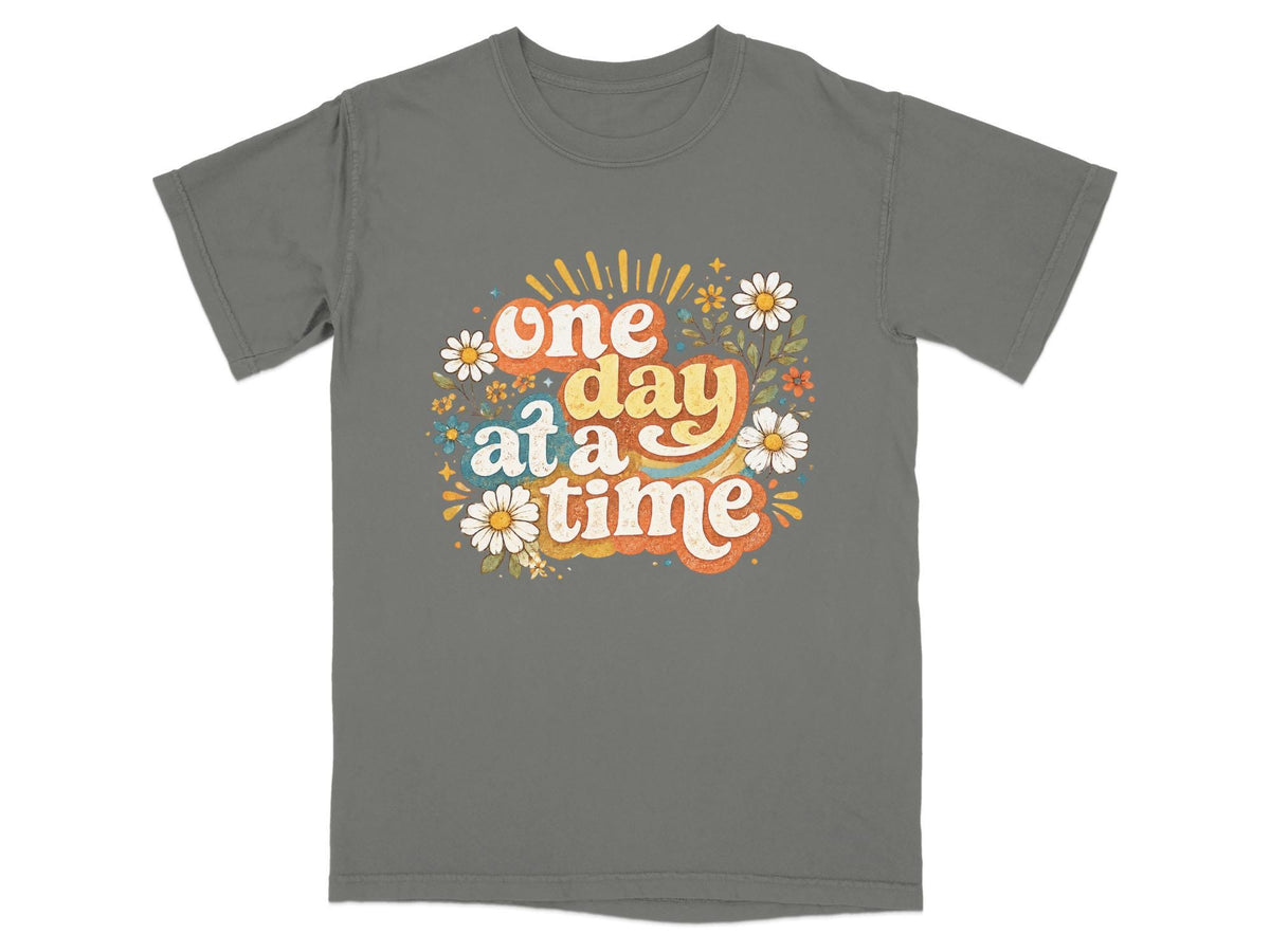 Grey t-shirt with "one day at a time" text and floral graphic.
