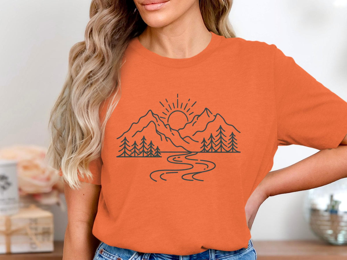 Orange t-shirt with a black outline design of mountains, trees, and a winding river.