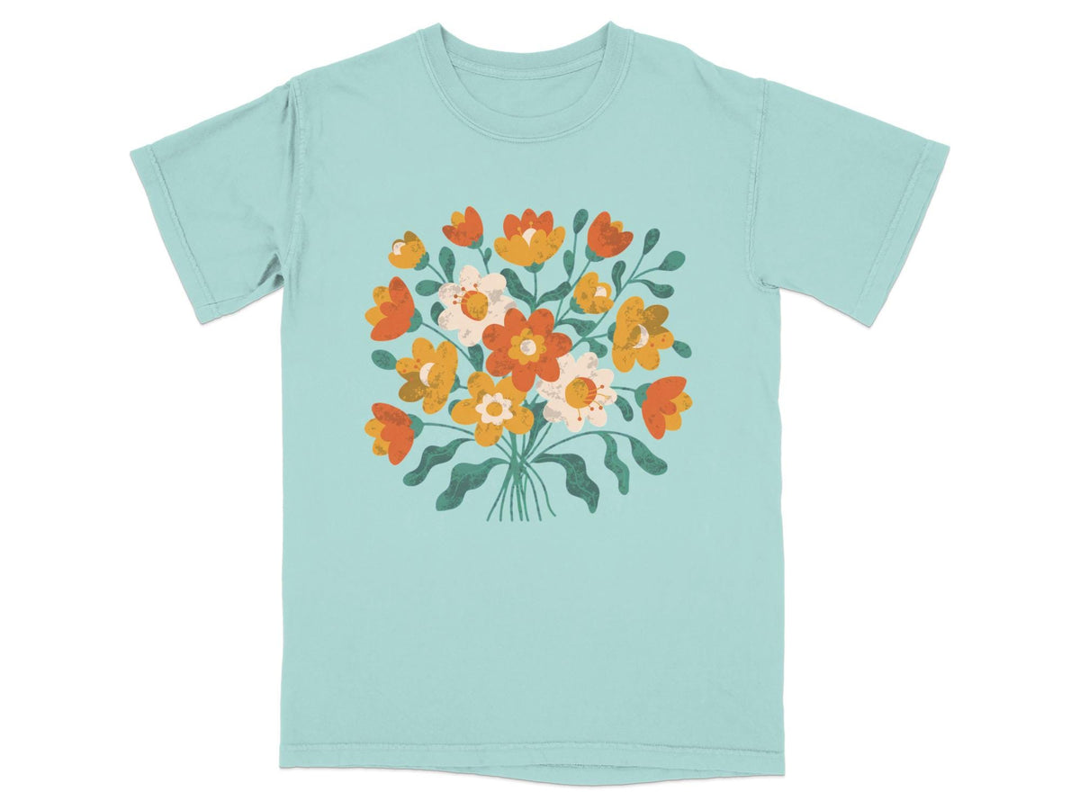 Light blue t-shirt with a bunch of orange, yellow, and white flowers.
