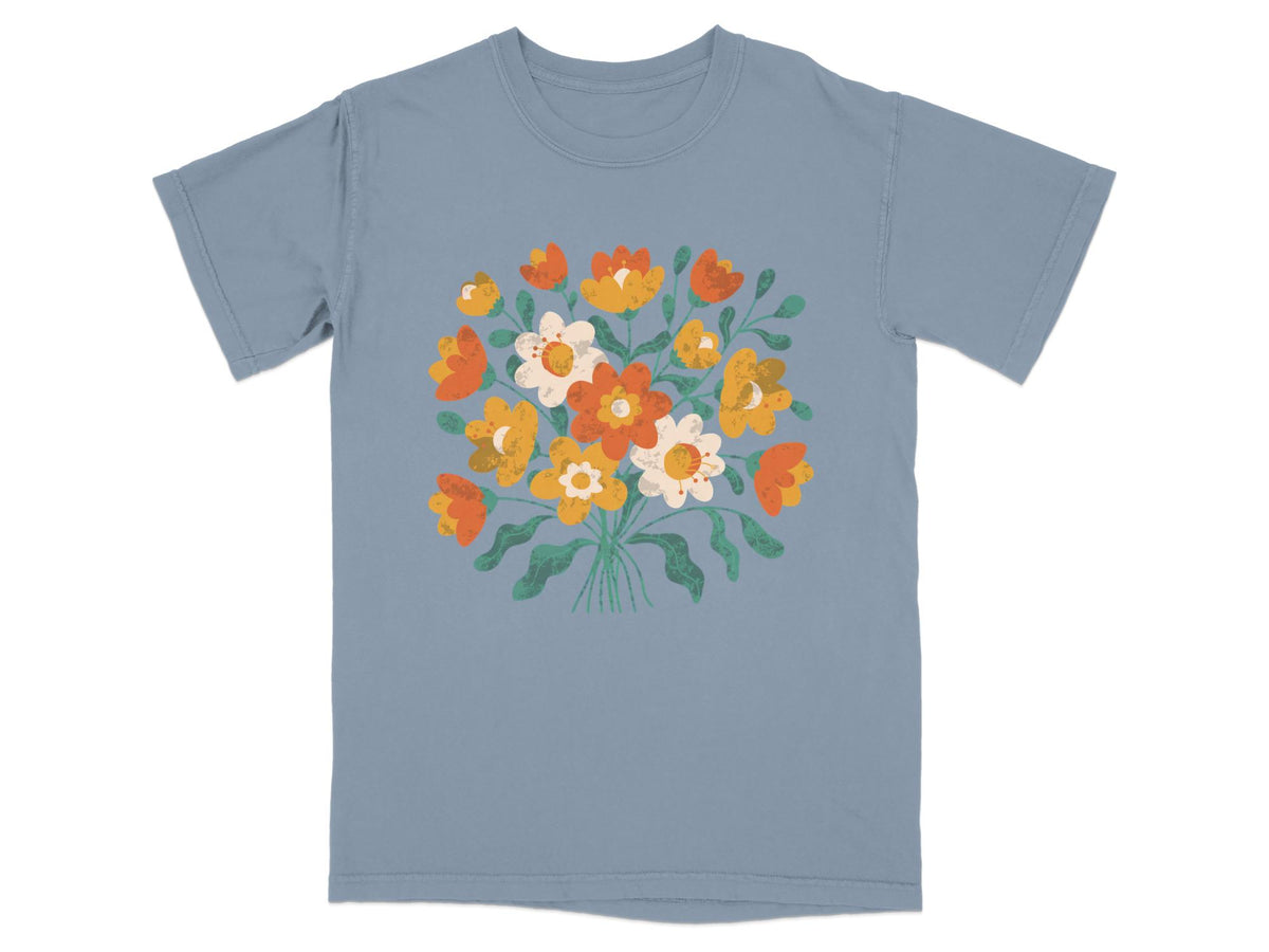 Blue t-shirt with a bouquet of orange, yellow, and white flowers.