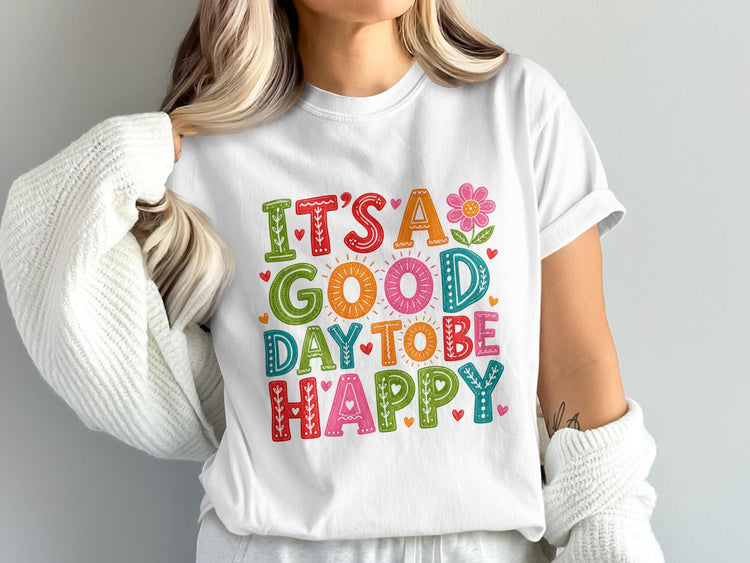 White t-shirt with "IT'S A GOOD DAY TO BE HAPPY" in colorful, decorative text.