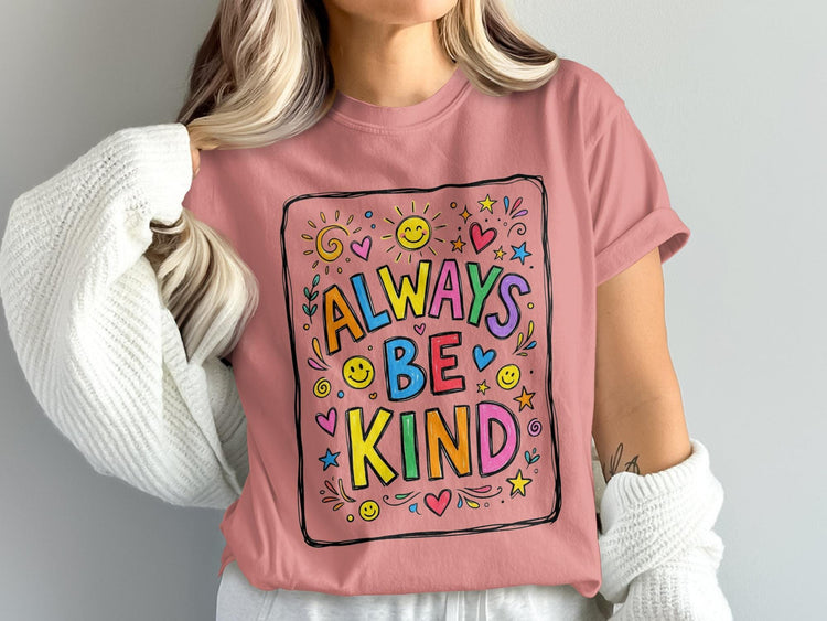 Pink t-shirt with "Always Be Kind" slogan surrounded by colorful illustrations.