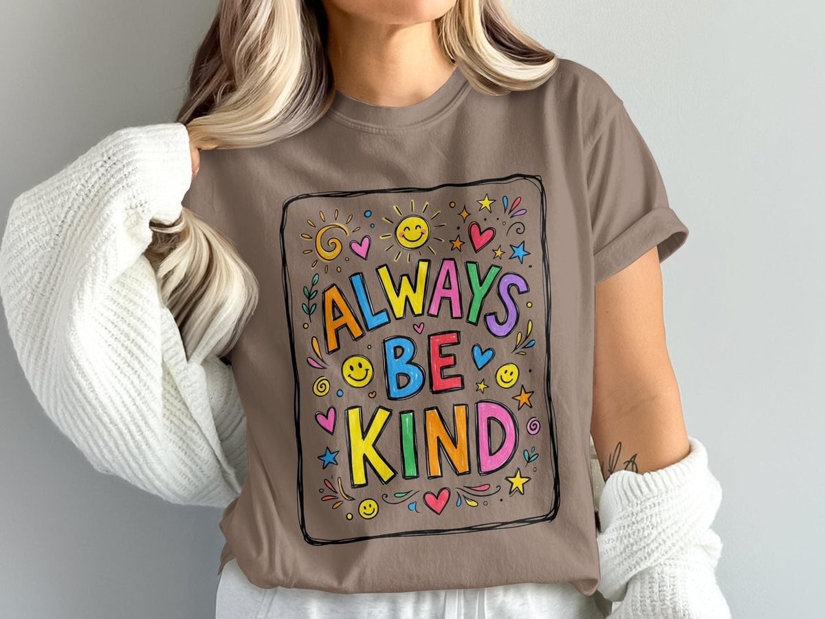 Brown t-shirt with "Always Be Kind" text and colorful sun, heart, and smiley face graphics.