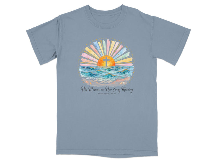 T-shirt with watercolor sunrise, cross, ocean waves, and biblical text.