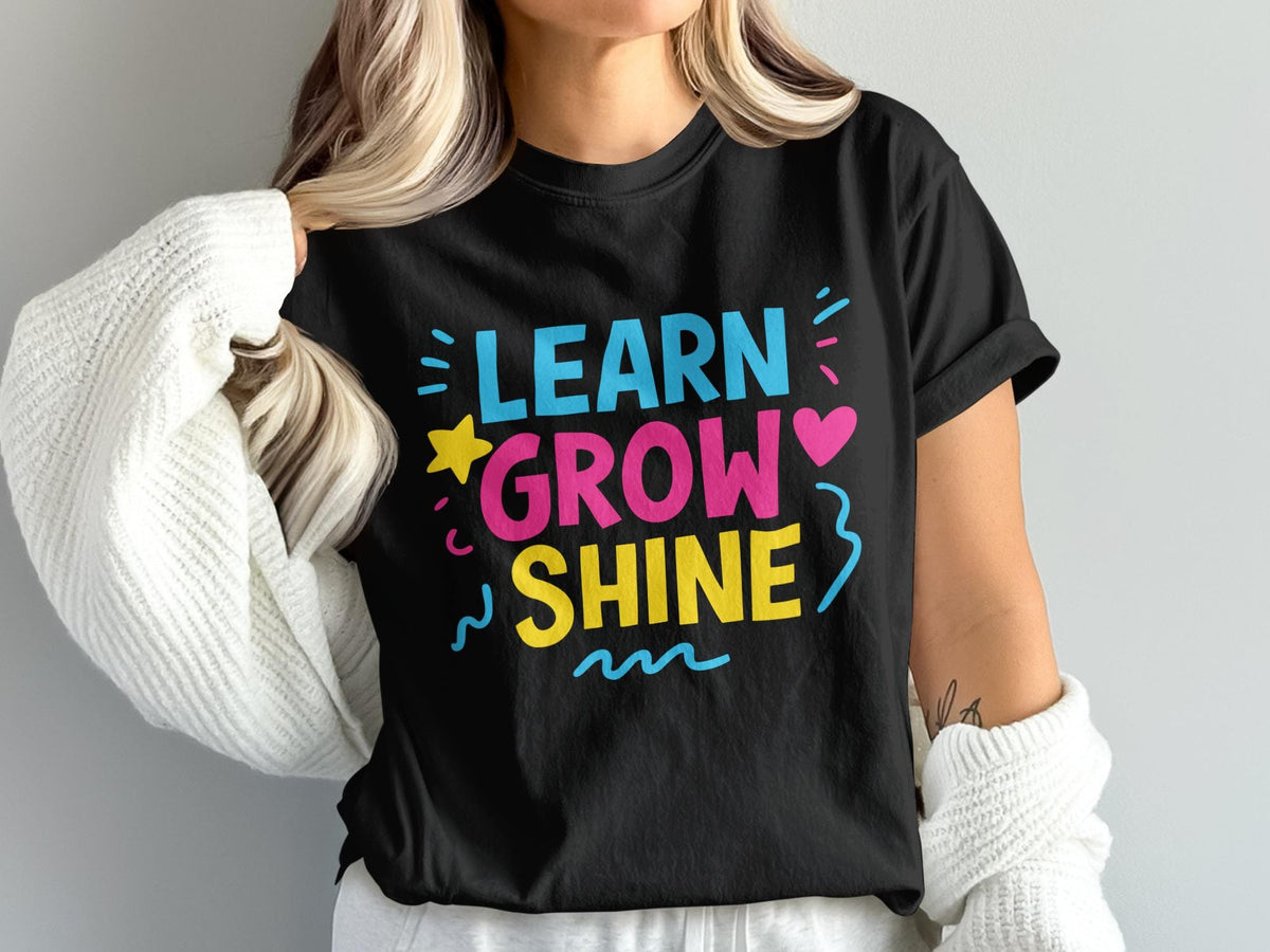 Black t-shirt with "LEARN GROW SHINE" in colorful text and graphics.